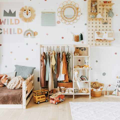 1. Children's room with wooden clothing rack holding colorful toddler clothes and toys, enhancing nursery decor