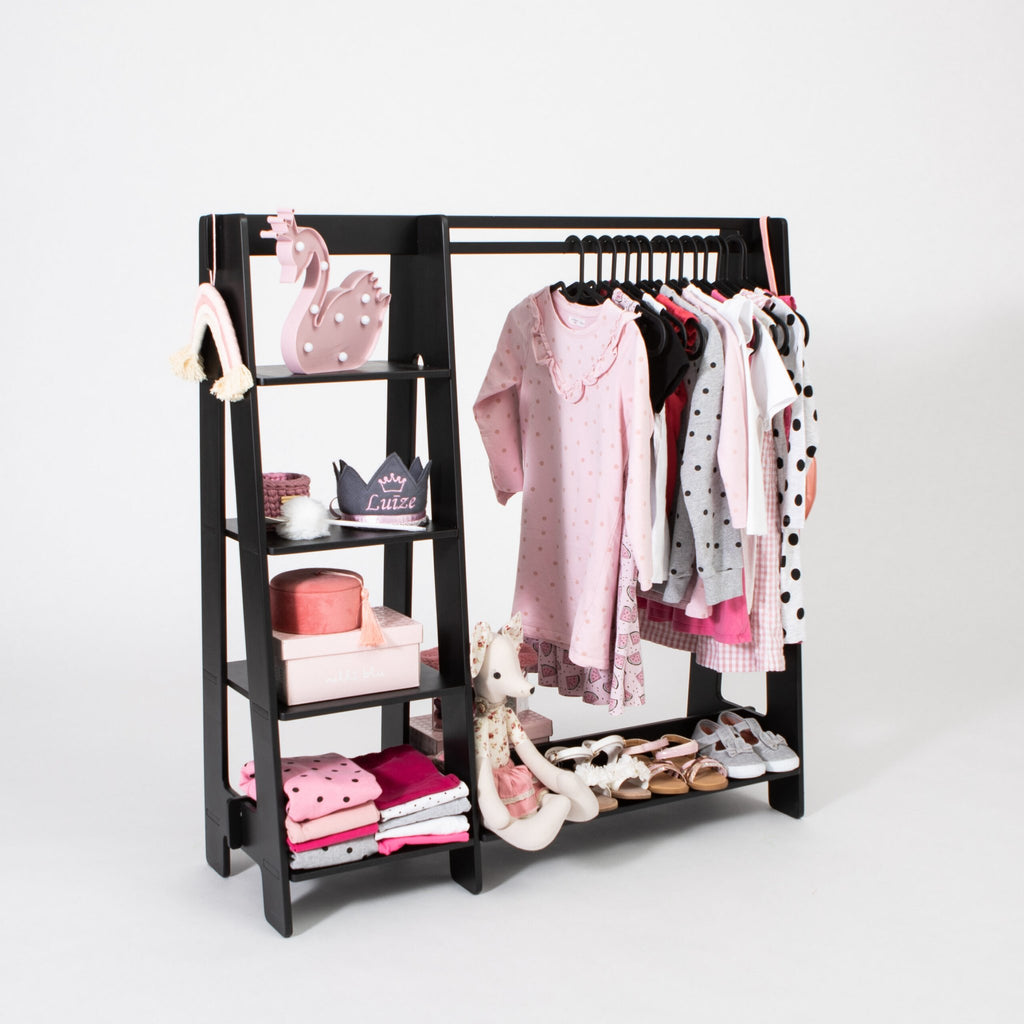 2. Black wooden clothing rack with pink toddler clothes and accessories on white background