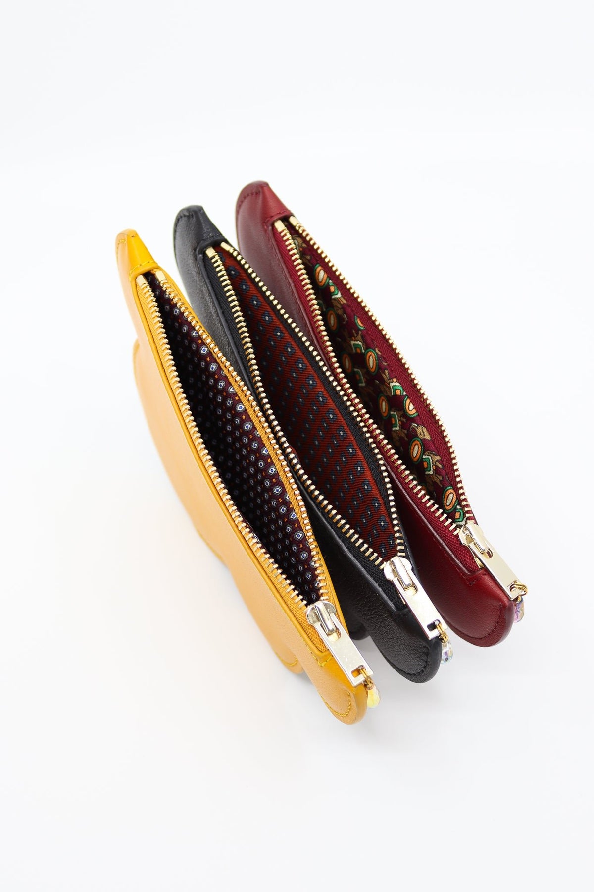 4. Close-up of Tairi Roosve cloud purses in mustard, black, and red, showing unique repurposed silk linings and Excella zips