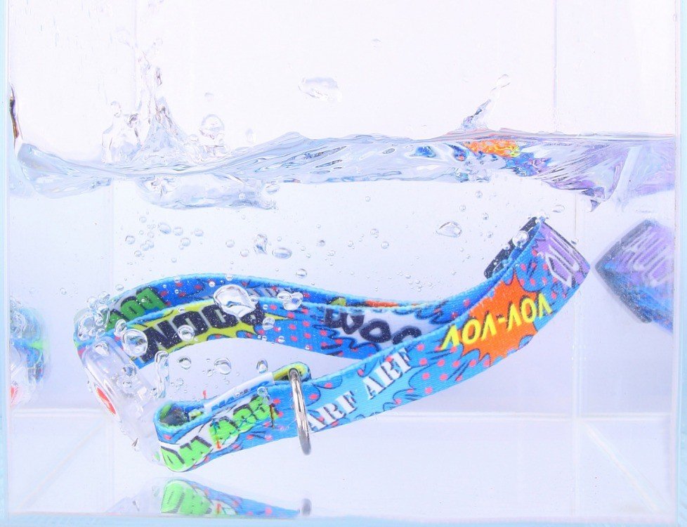 2. Blue graffiti-patterned dog collar submerged in water, highlighting waterproof feature
