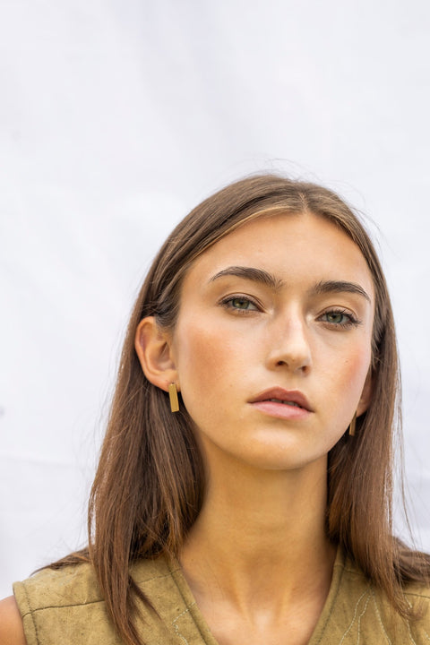 1. Woman wearing Lentsius Sunlit earrings, looking forward against a light background