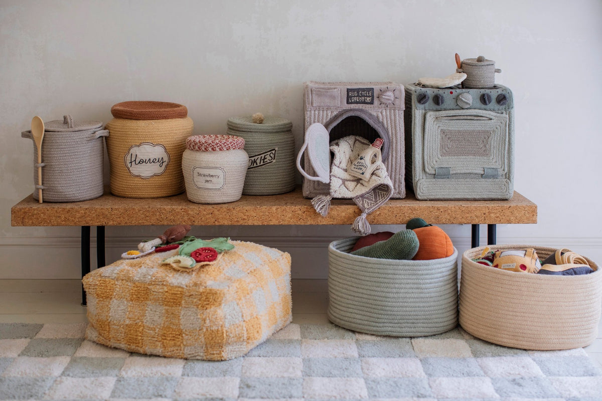 9. Lorena Canals textile toy kitchen set with storage baskets on wooden bench