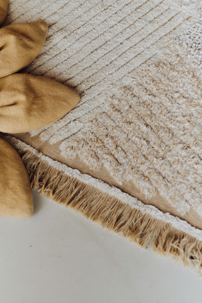 4. Detail of Lorena Canals cotton play rug with textured fabric and fringe edge in natural colors