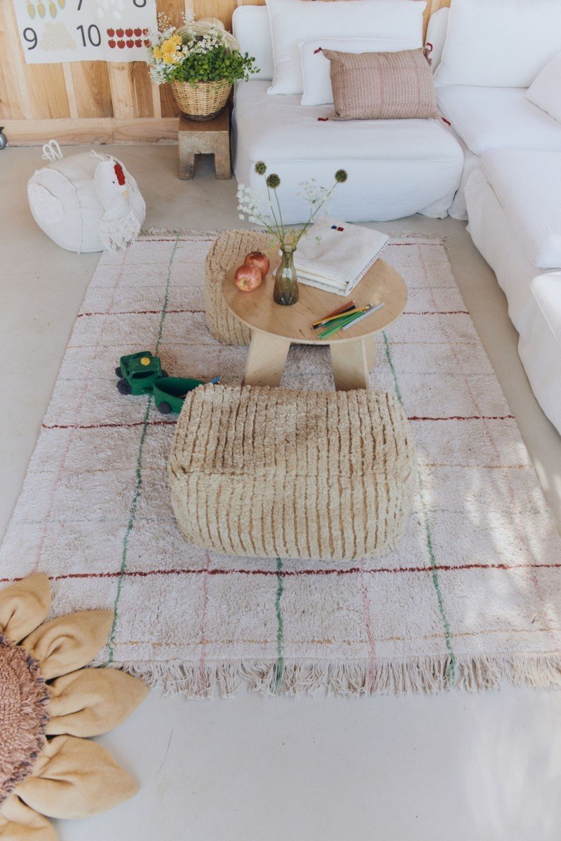 1. Natural cotton rug with multicolor stripes in a living room with poufs and a small table