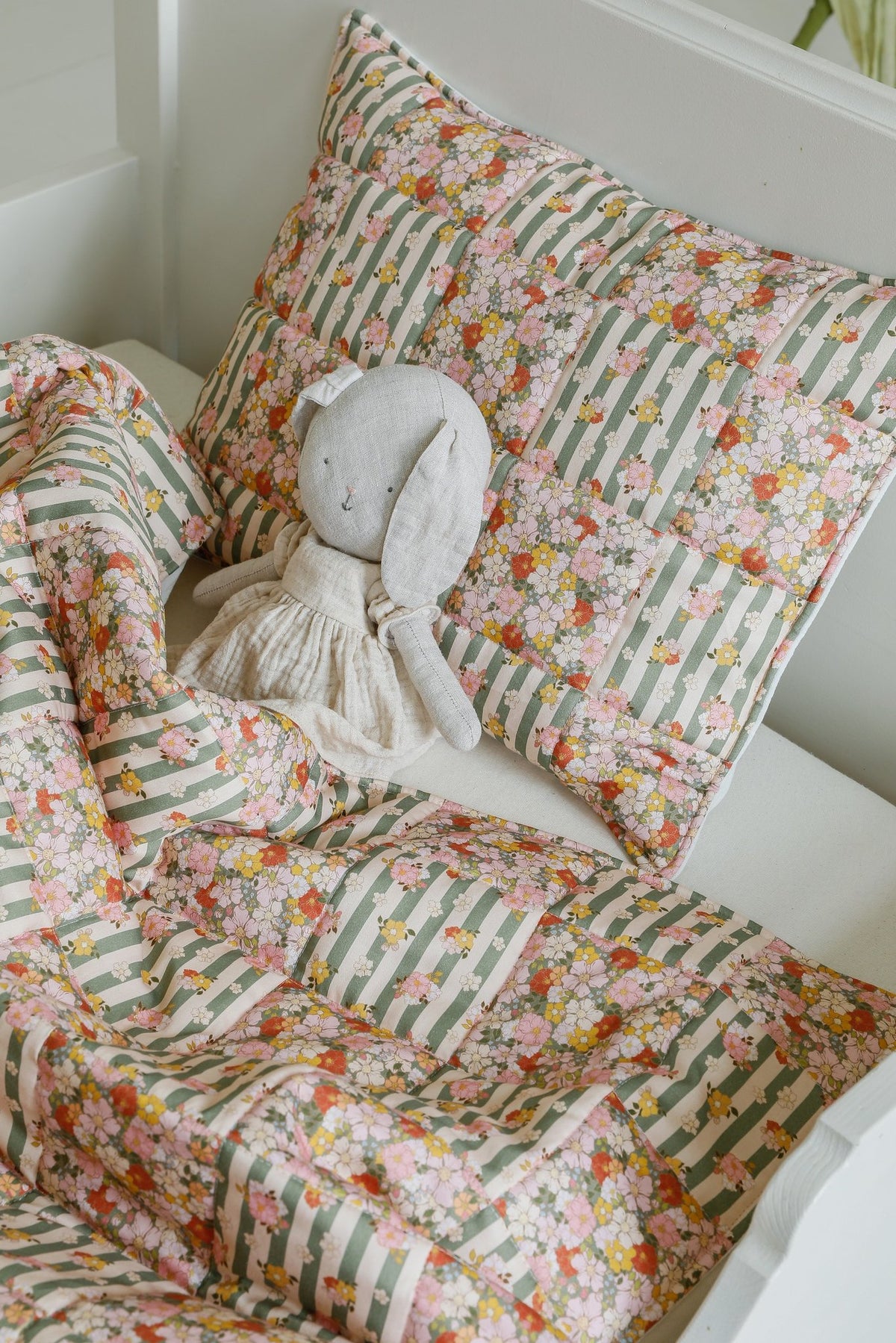 4. Close-up of Moi Mili cotton quilted patchwork blanket and pillow set in green garden pattern with stuffed toy