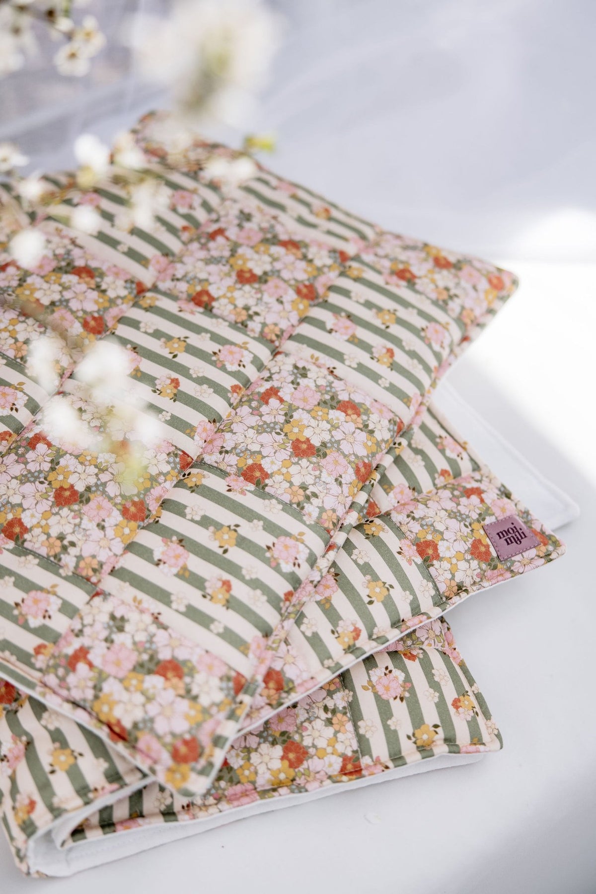 6. Detail shot of Moi Mili cotton quilted patchwork blanket in green garden pattern with floral accents