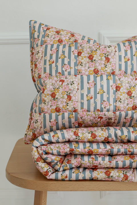 1. Cotton quilted patchwork blanket and pillow set with floral and striped pattern on wooden bench