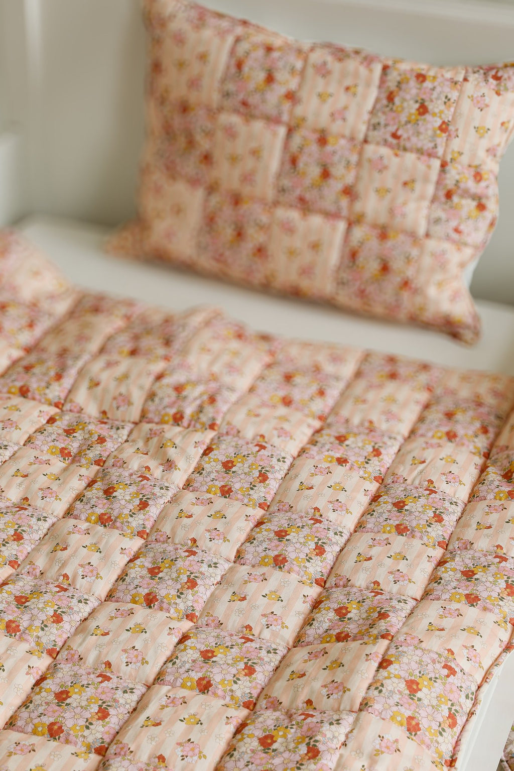 2. Close-up of floral cotton quilted blanket and pillow set on bed showing patchwork detail