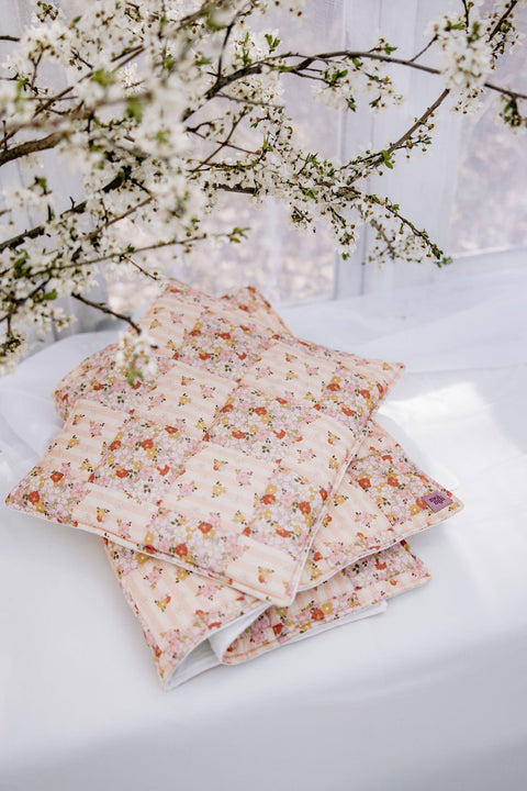 3. Cotton quilted patchwork blanket and pillow set in floral pattern on white surface with branches