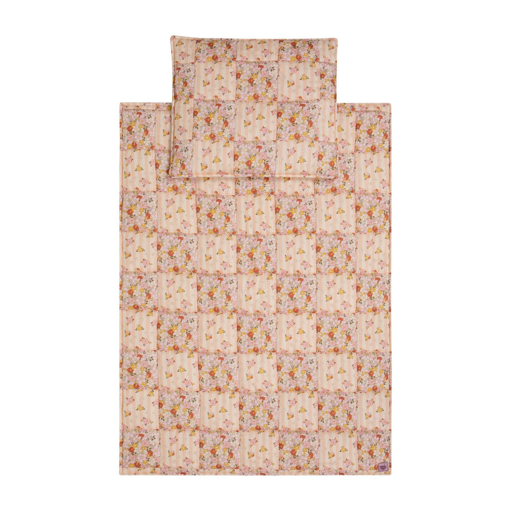 1. Flat lay of Moi Mili cotton quilted patchwork blanket and pillow set in floral pattern on white background