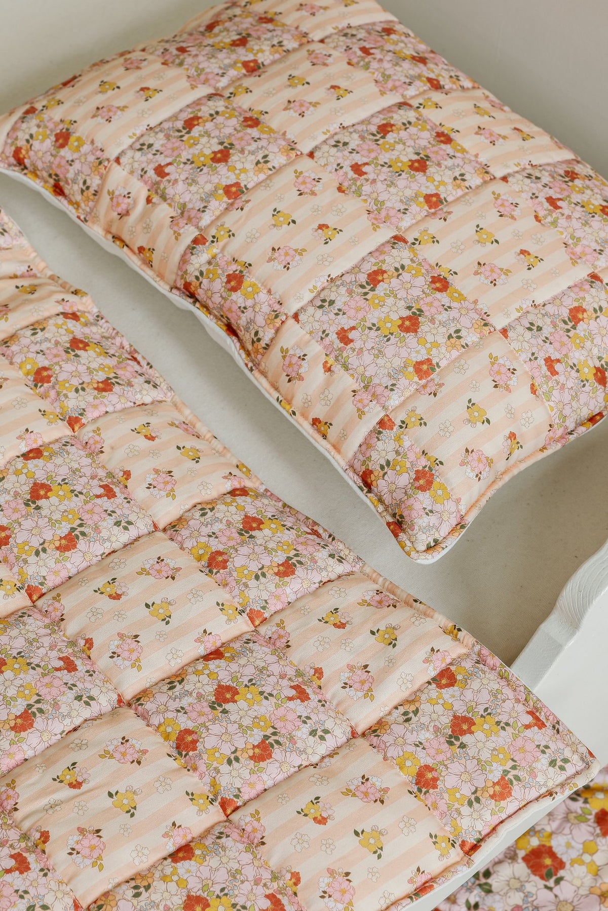 5. Detail of cotton quilted patchwork blanket and pillow set in floral pattern on bed
