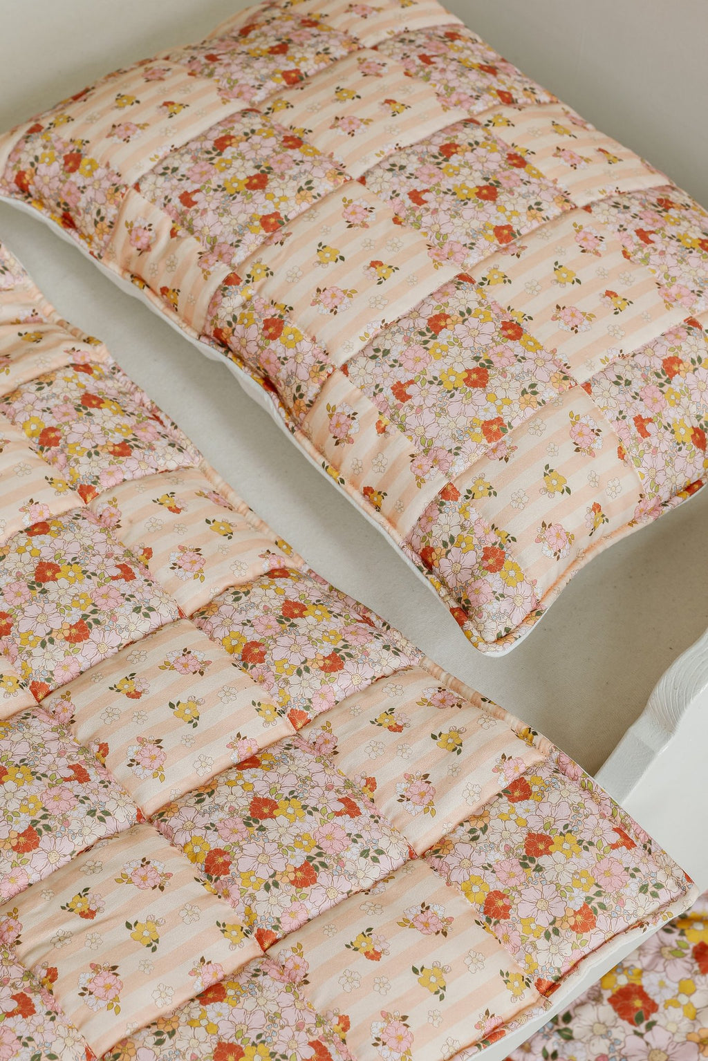 3. Detail shot of floral patchwork design on cotton quilted pillow and blanket set