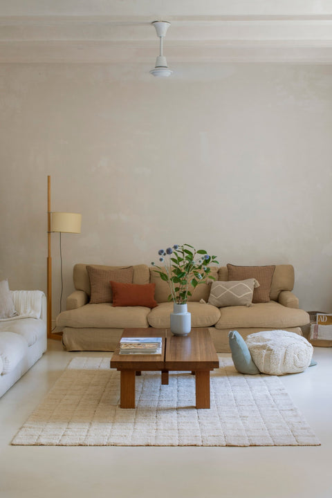 1. Living room with beige sofas and a wooden coffee table on a Lorena Canals toffee-colored mosaic cotton rug