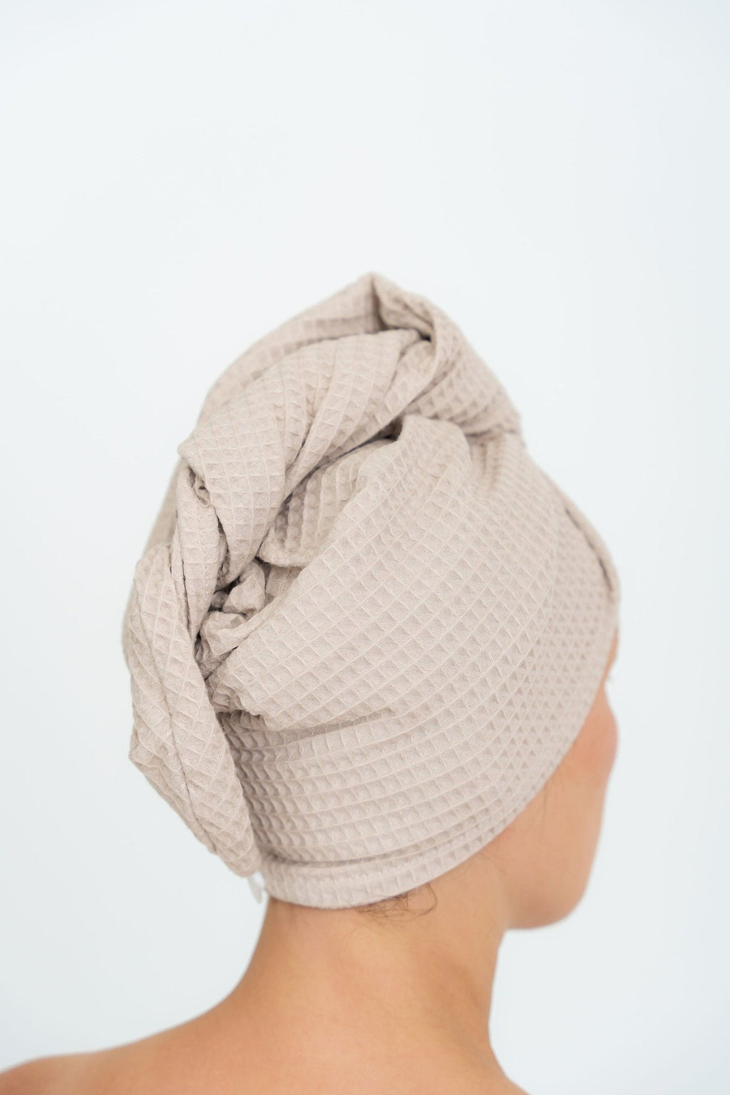 10. Woman with back turned wearing beige cotton waffle hair towel turban