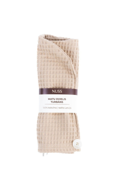 2. Beige cotton waffle hair towel turban folded with Nuss branding on white background
