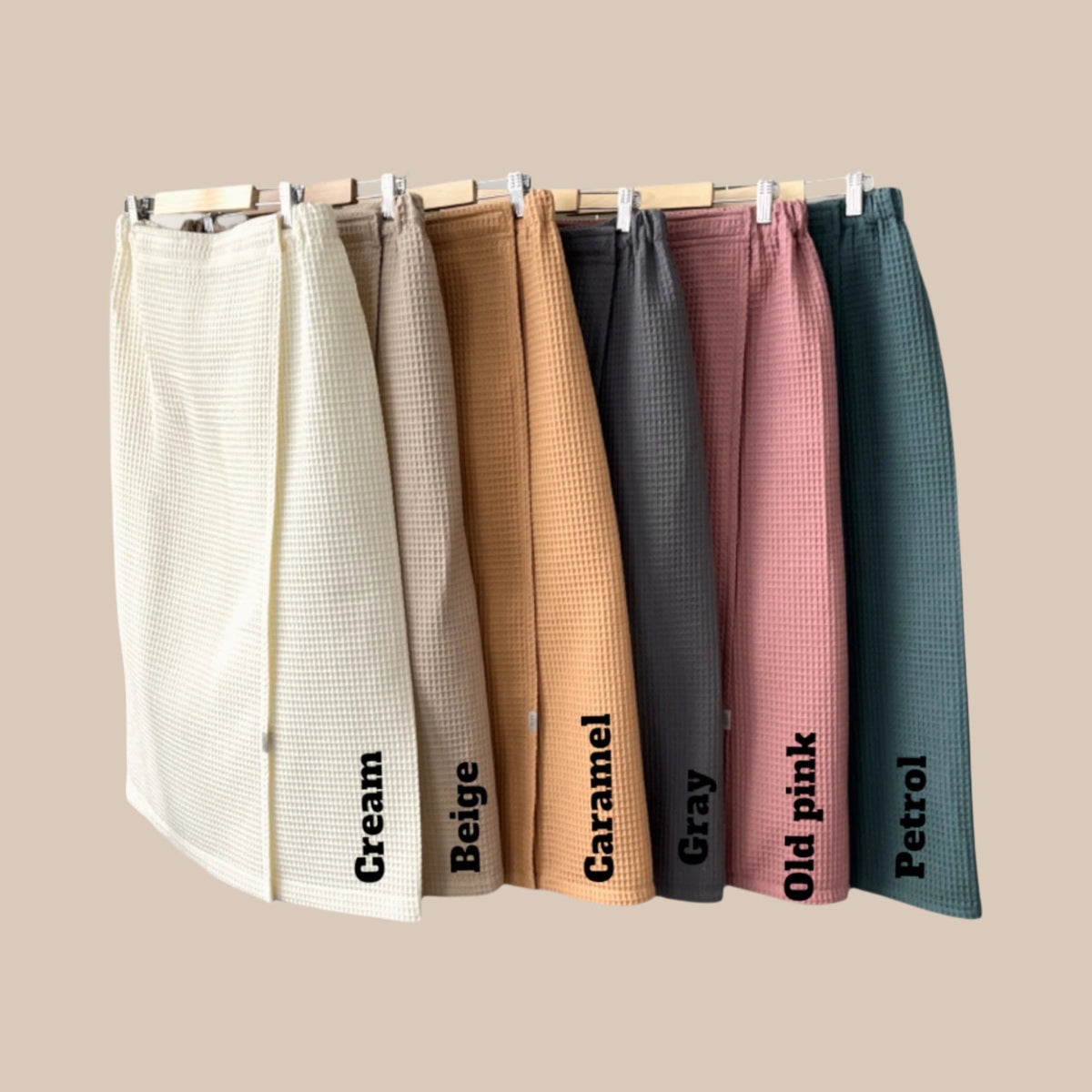 4. Flat lay of cotton waffle sauna wraps in cream, beige, caramel, gray, old pink, and petrol colors
