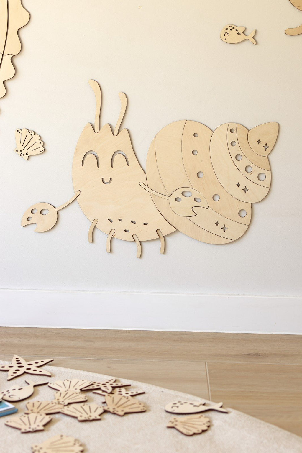 6. Wooden crab wall decoration with smiling face and shell details on a wooden floor