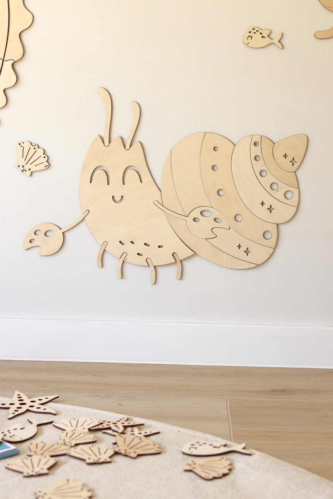 6. Wooden crab wall decoration with smiling face and shell details on a wooden floor