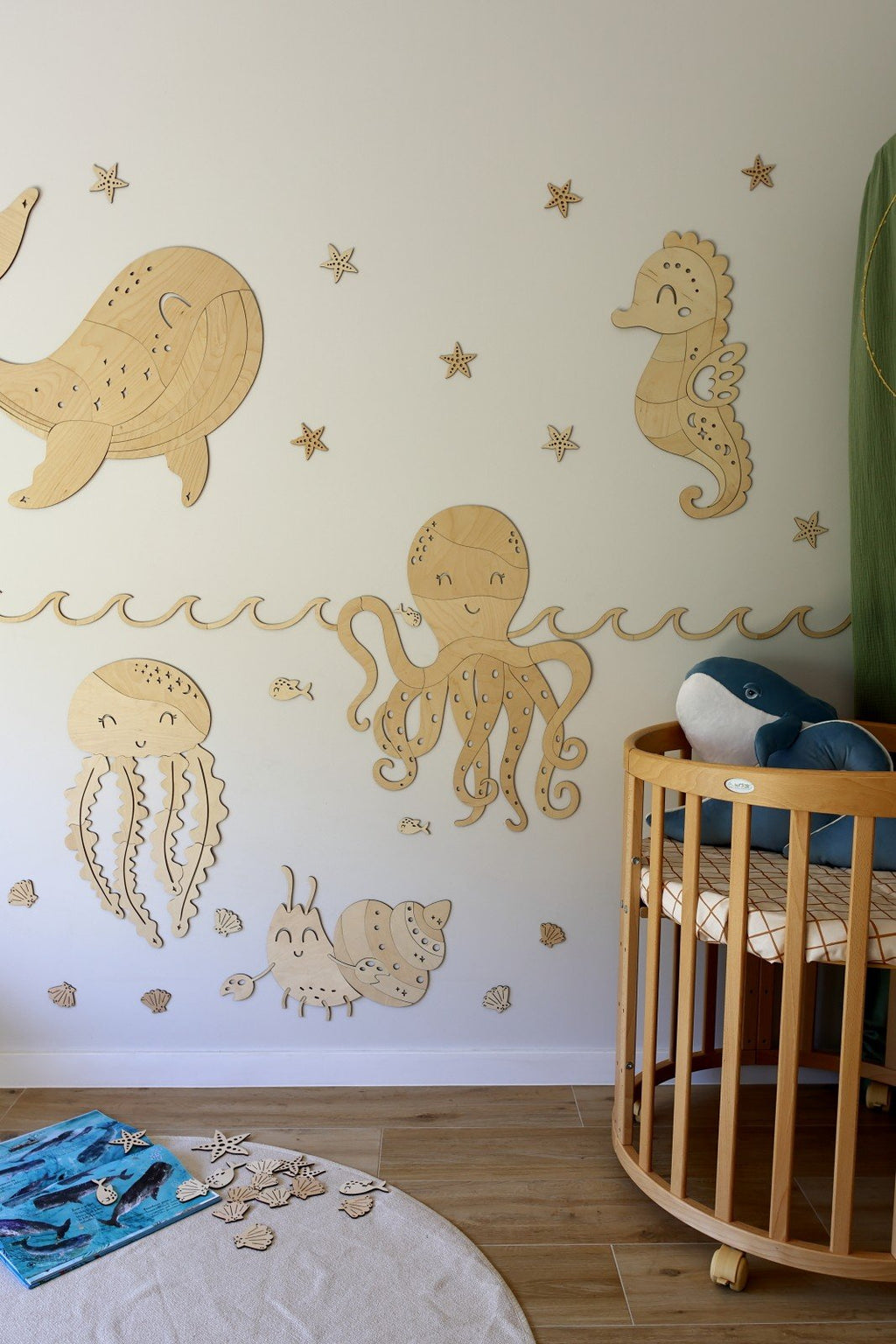 7. Nursery with ocean-themed wooden wall decorations including a crab, octopus, and seahorse