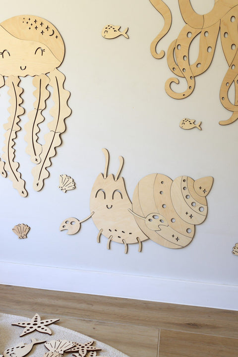 1. Children's room with wooden ocean-themed wall decorations including a crab, jellyfish, and octopus on a white wall