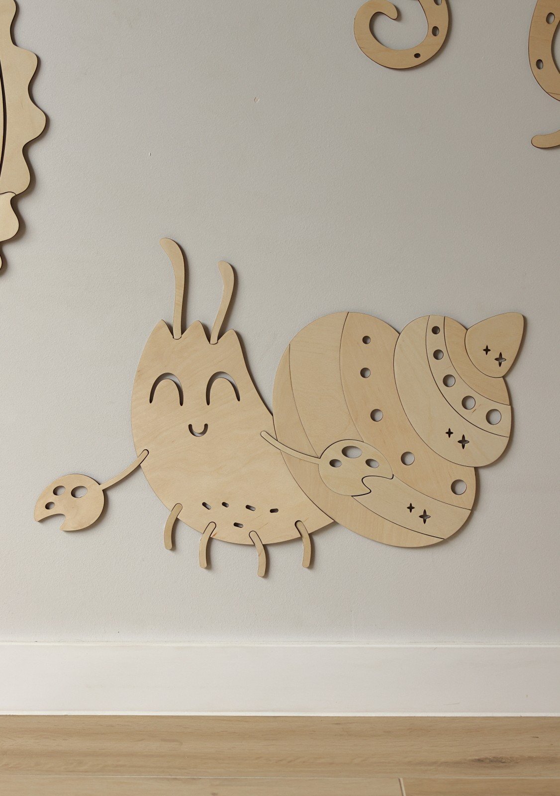5. Wooden crab wall decoration with smiling face and detailed shell on a light wall