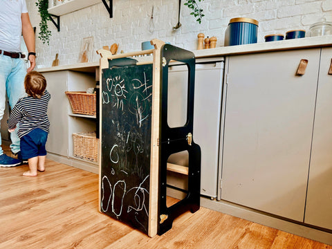 3. Black learning tower with chalk drawings on the blackboard in a kitchen