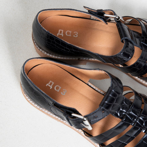 3. Close-up of Daz Studio branding inside black croc fisherman sandals, showing leather interior