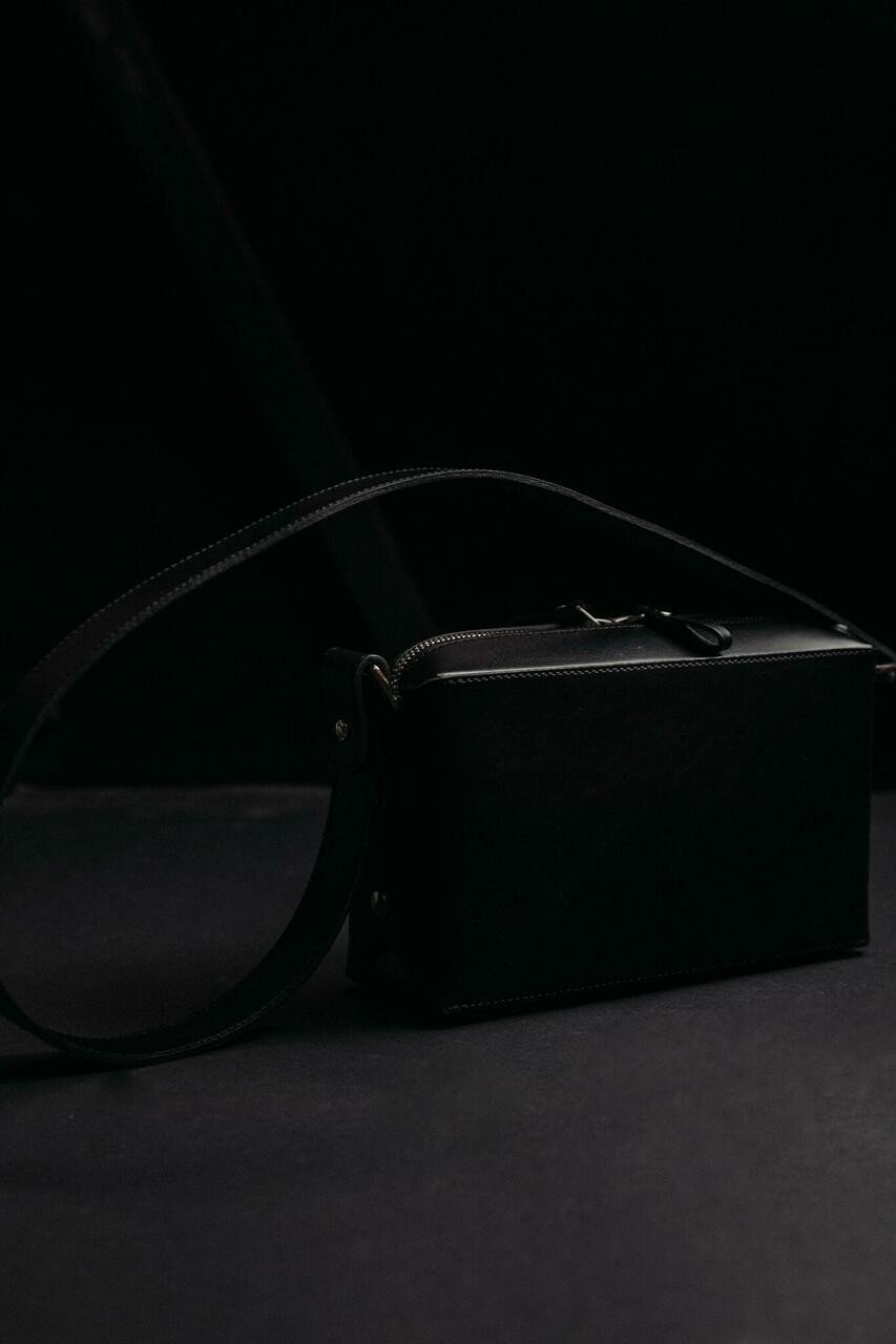 2. Stella Soomlais black crossbody bag on dark studio background highlighting leather texture