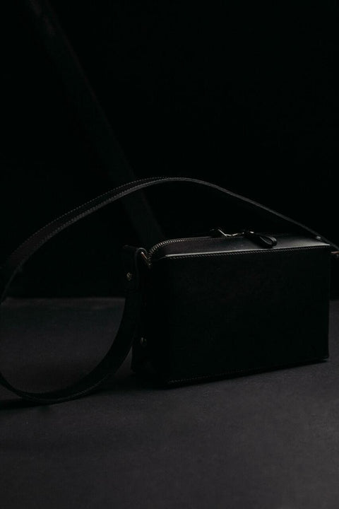 2. Stella Soomlais black crossbody bag on dark studio background highlighting leather texture