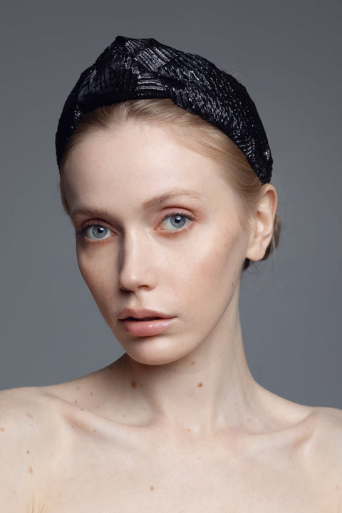 1. Women's Knot Headband Holly by Eva Oherjus in black with shimmering metallic threads, worn by a female model