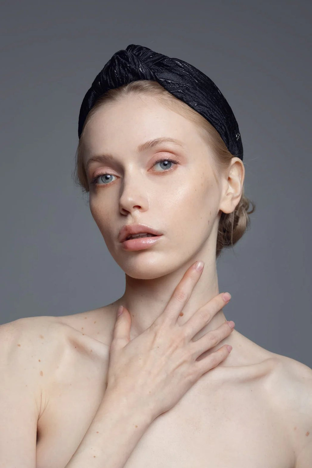 1. Women's Knot Headband Lola by Eva Oherjus in black with shimmering metallic threads, worn by model in studio setting