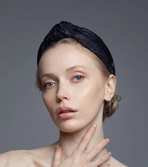 2. Women's Knot Headband Lola by Eva Oherjus in black with shimmering metallic threads, worn by model in studio setting