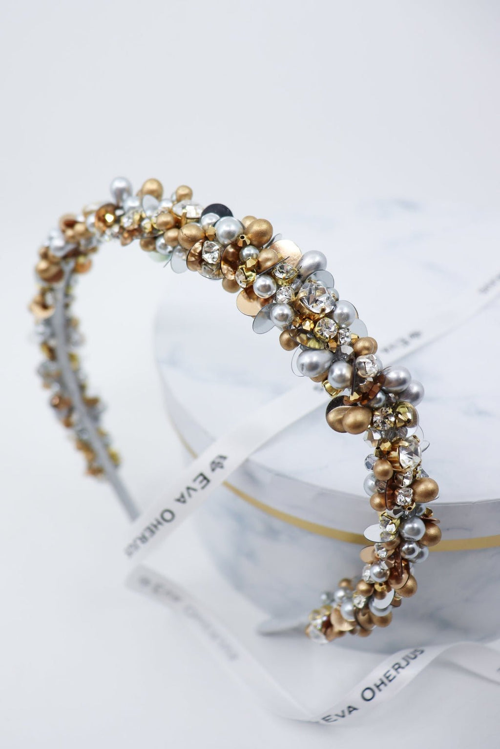 4. Eva Oherjus Lena headband with crystals and pearls displayed on luxury hat box