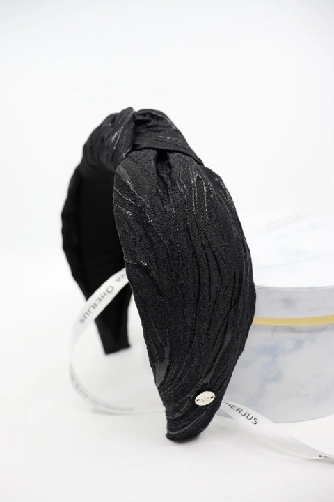 3. Studio shot of Eva Oherjus Knot Headband Lola in black with metallic threads, featuring gold logo tag