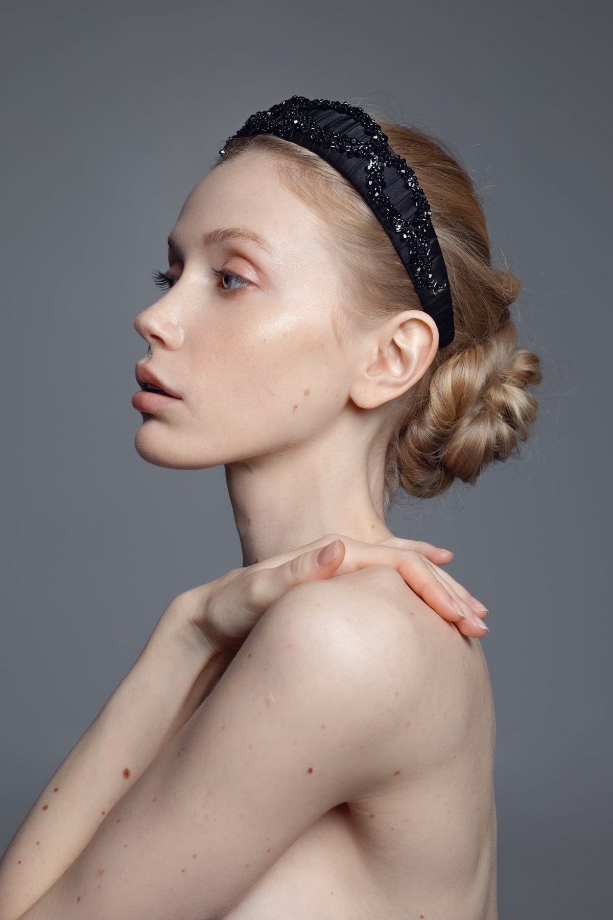 3. Side profile of woman wearing Eva Oherjus Mulberry Silk Beaded Headband Hestia, highlighting black shiny beads and elegant design
