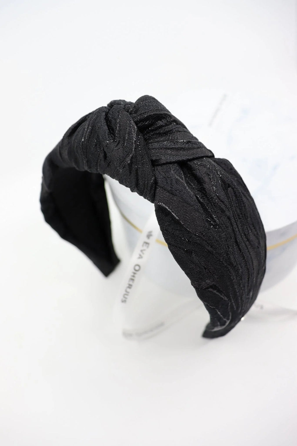4. Studio shot of Eva Oherjus Knot Headband Lola in black with metallic threads, highlighting fabric texture