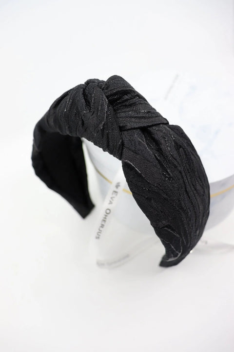 4. Studio shot of Eva Oherjus Knot Headband Lola in black with metallic threads, highlighting fabric texture