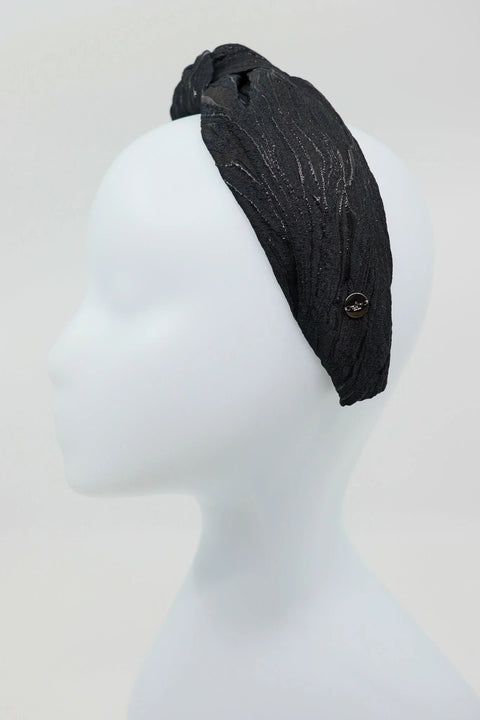 5. Side view of Eva Oherjus Knot Headband Lola in black with metallic threads, shown on mannequin