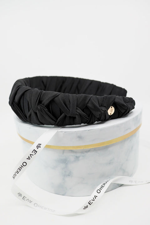 4. Black Mulberry silk knotted headband by Eva Oherjus with gold logo tag on luxury hat box