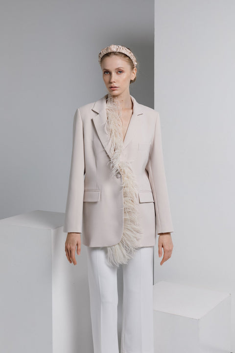 1. Woman wearing Eva Oherjus Jenna Mulberry Silk Knotted Headband in light beige, styled with a chic blazer in a studio setting