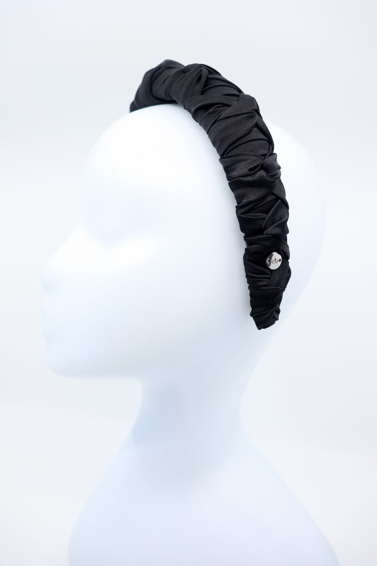 3. Women's black Mulberry silk knotted headband with silver logo tag by Eva Oherjus on mannequin