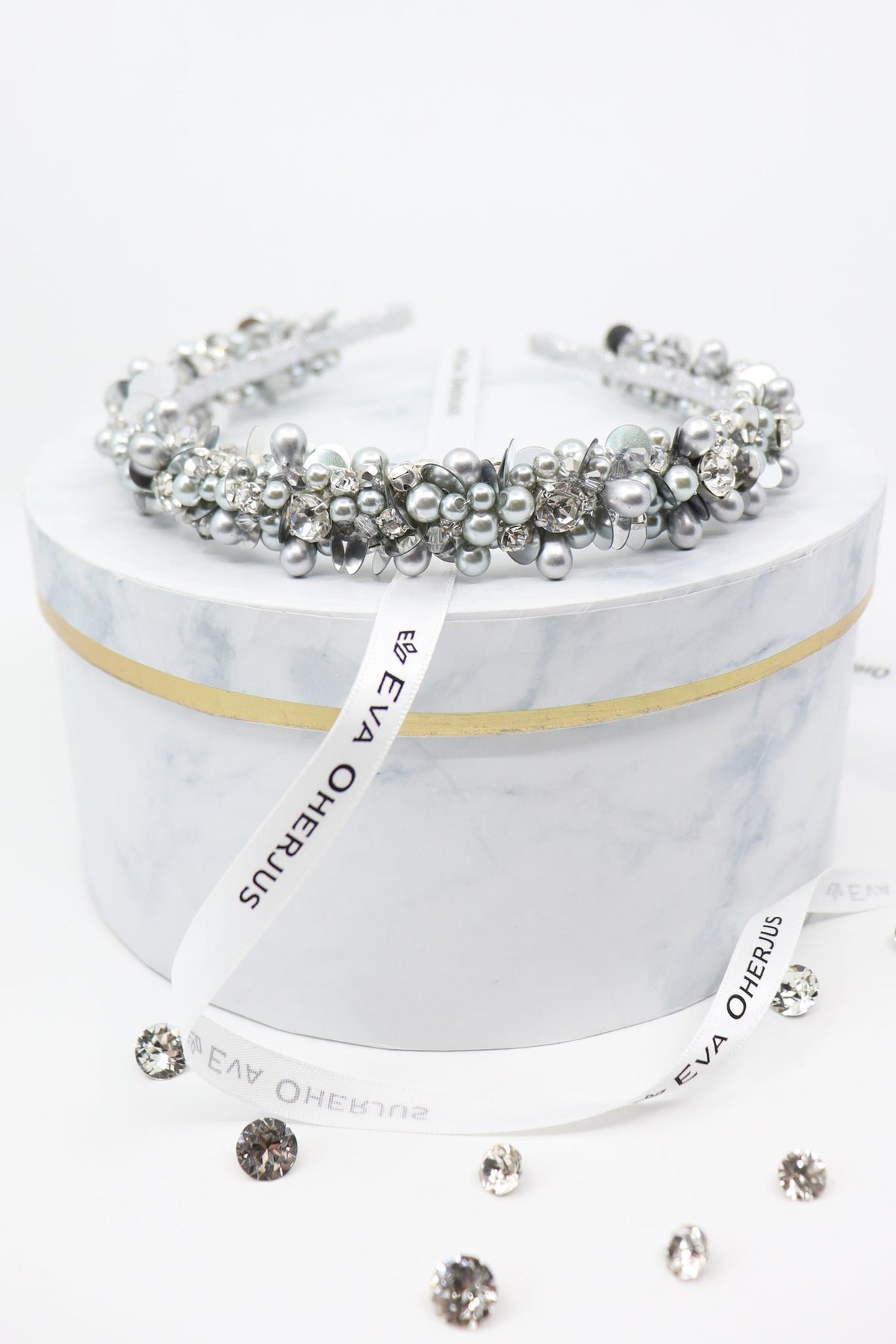 2. Eva Oherjus Selena headband adorned with crystals and pearls on marble hat box