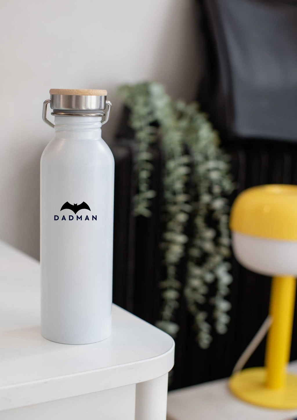 1. White DADMAN thermos bottle with bamboo lid on a table in a modern room setting