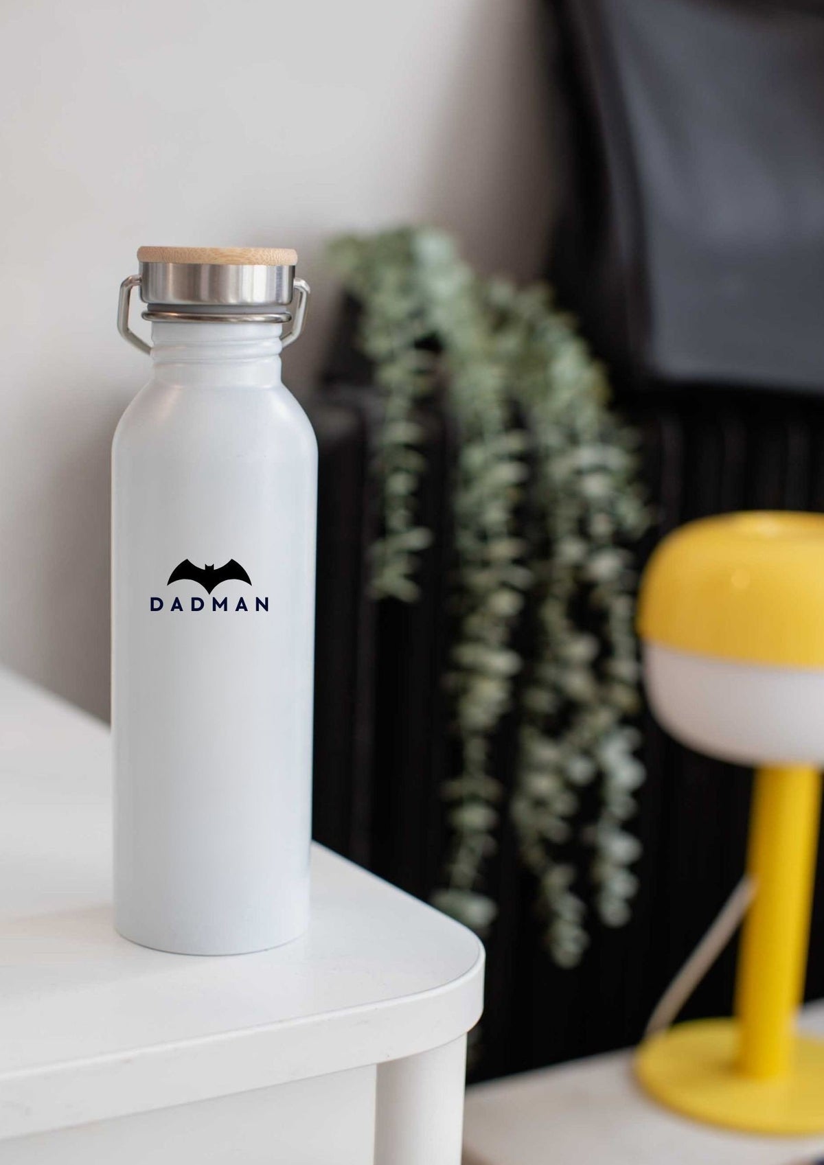 1. White DADMAN thermos bottle with bamboo lid on a table in a modern room setting