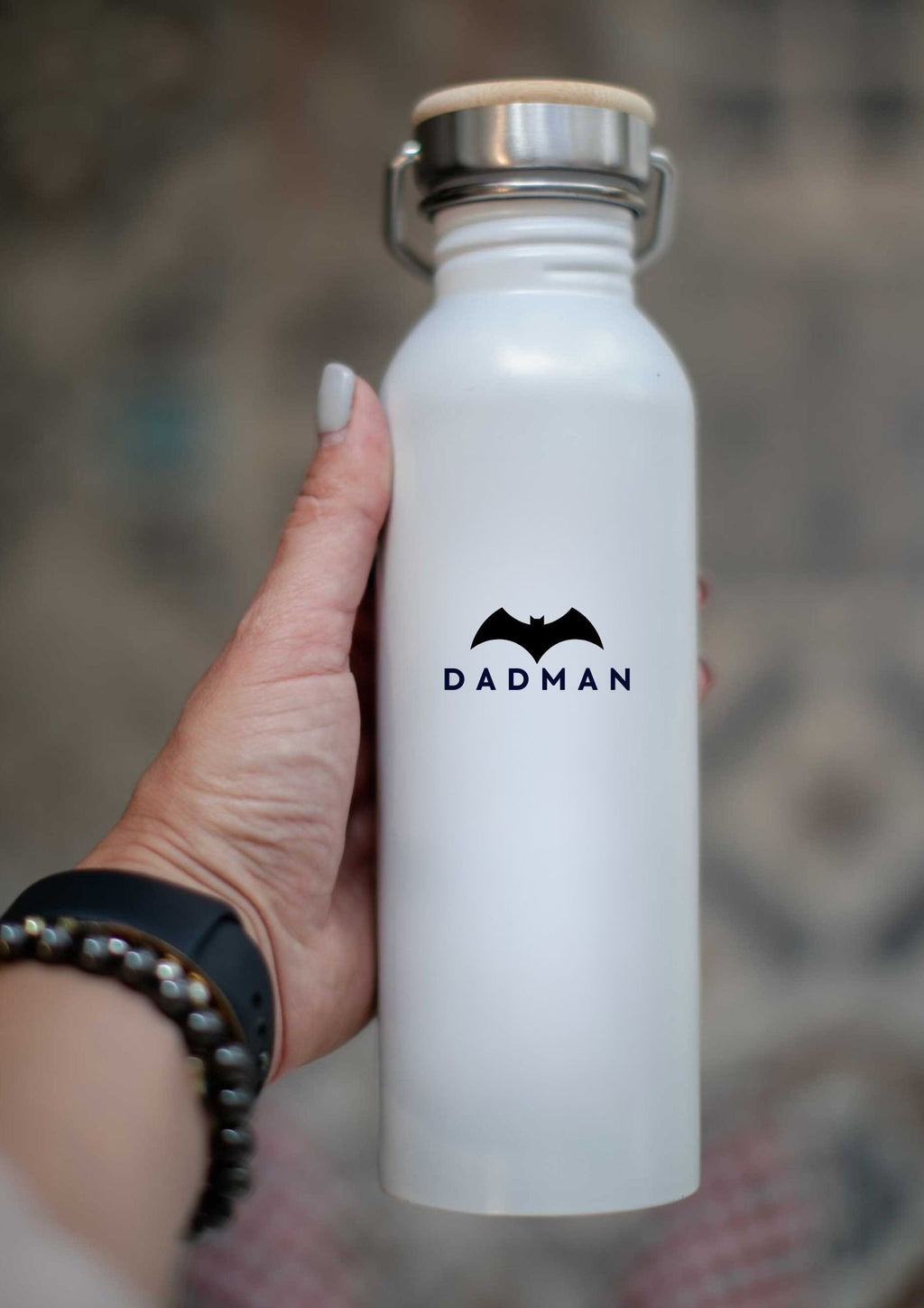 4. Close-up of hand holding white DADMAN thermos bottle with bamboo lid