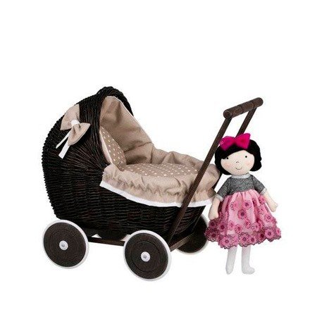 6. Dark painted wicker doll pram with beige bedding and a doll in pink dress hanging on handle, studio setting
