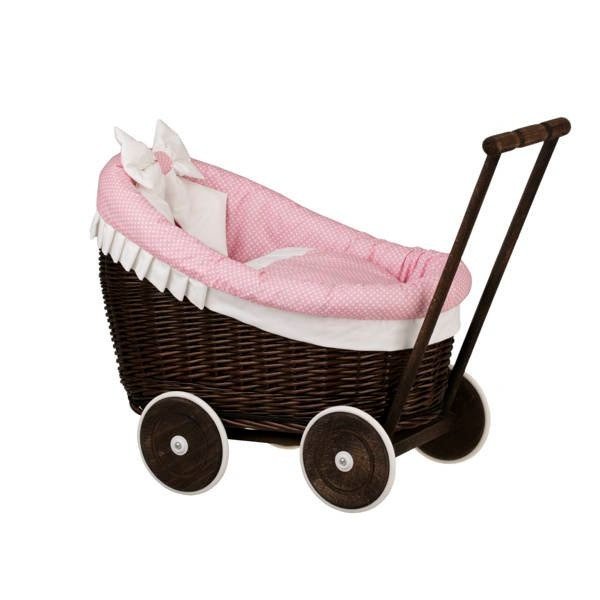 2. Side view of dark painted wicker doll pram with pink bedding and wooden handle