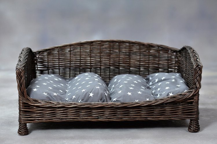 1. Dark wicker pet bed with grey star-patterned cushion on neutral background, showcasing front view