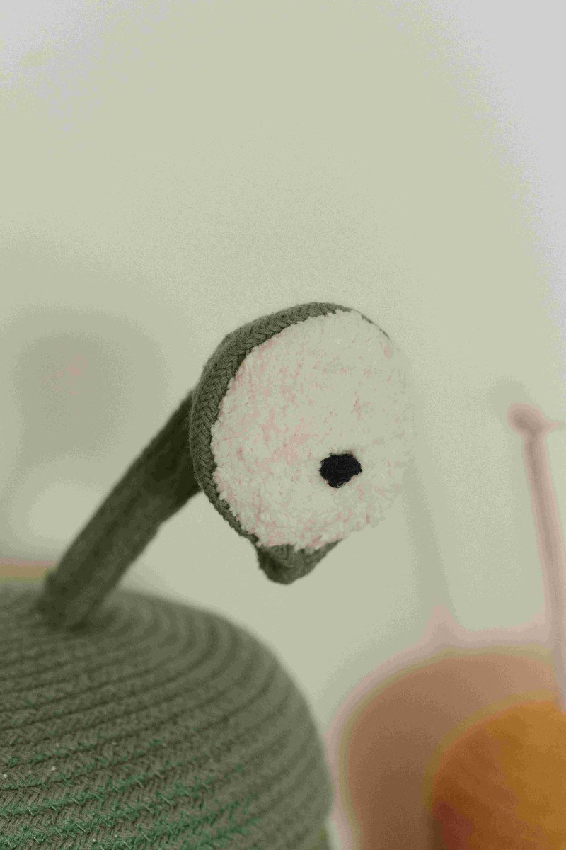 3. Close-up of green alien basket's white pom-pom eye with black pupil, highlighting texture and detail