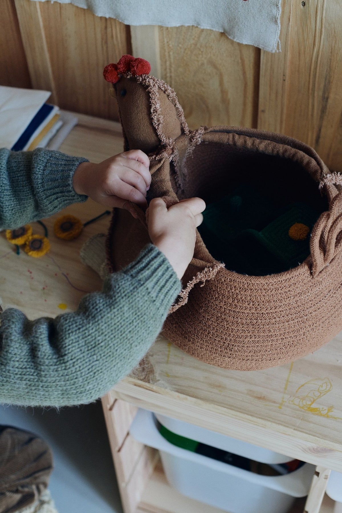 2. Close-up of Lorena Canals chicken pouf being opened by a child, showing its functional storage space